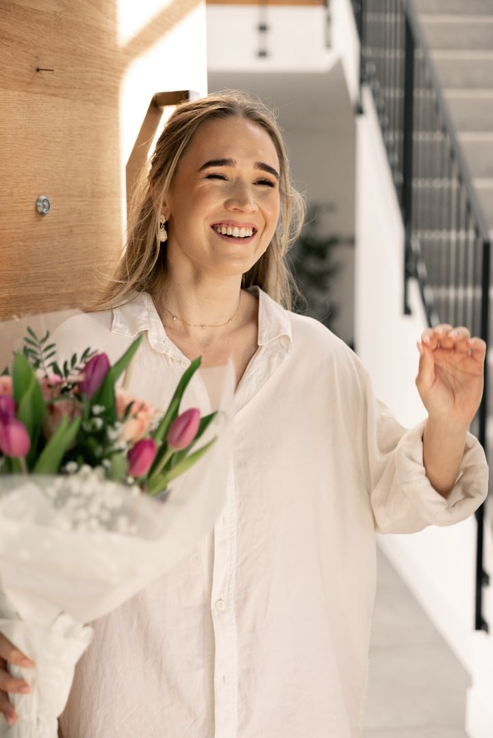 Tess laughing, holding a bouquet of tulips
